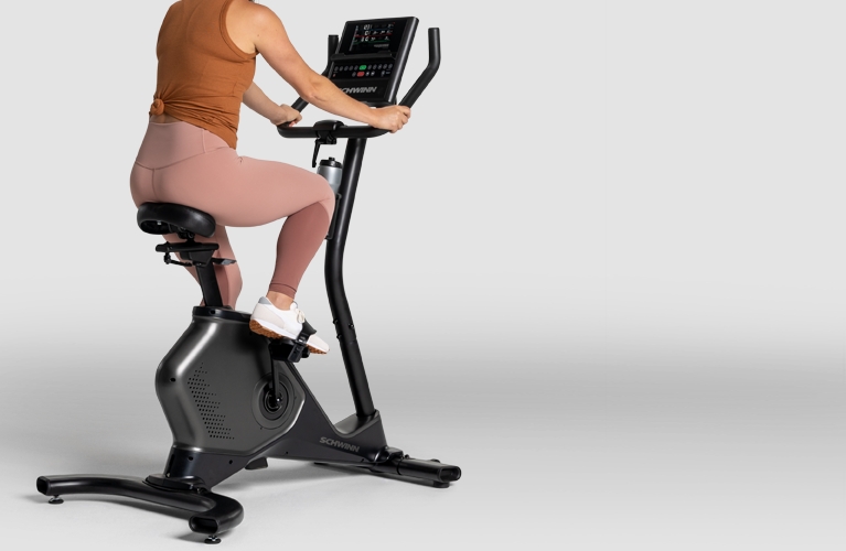 Woman riding a Schwinn upright exercise bike